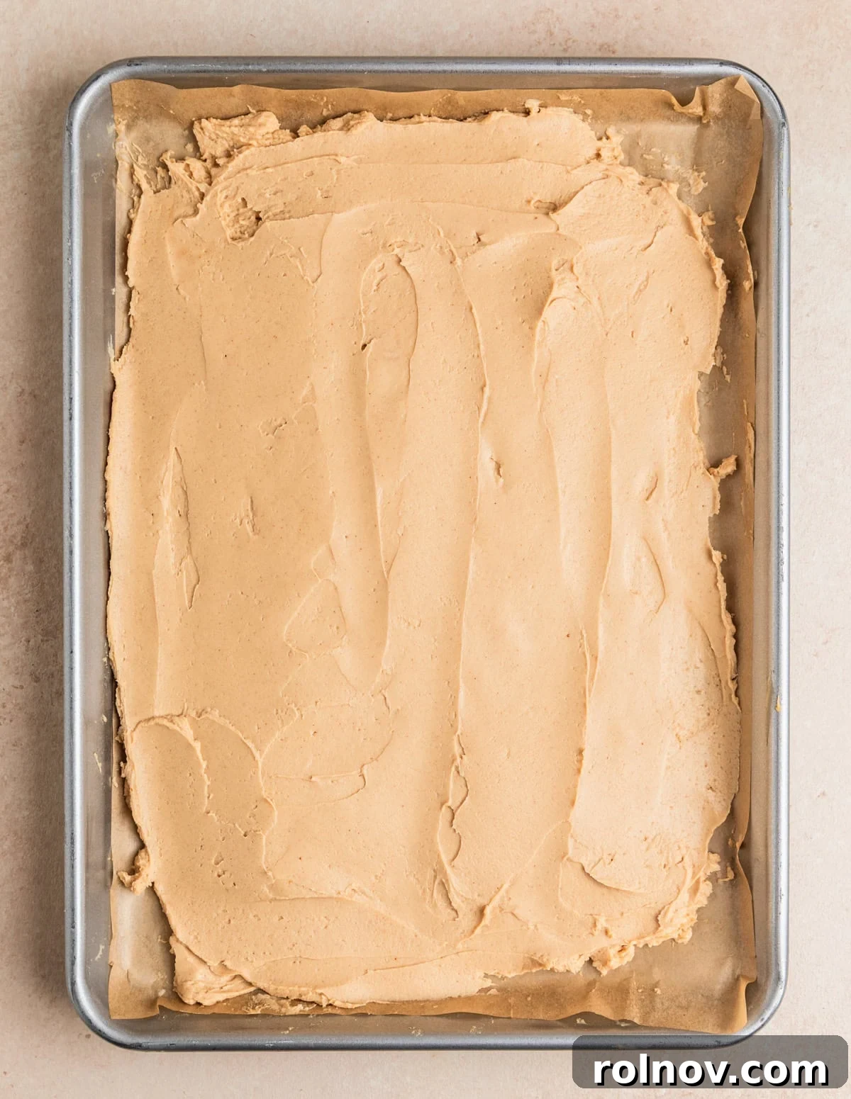 Frozen Greek Yogurt Bites 6 Peanut butter and Greek yogurt mixture evenly spread onto a parchment lined baking sheet, forming the base layer.