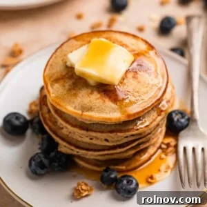 Stack of hot cakes made with bananas and oats topped with butter and maple syrup.