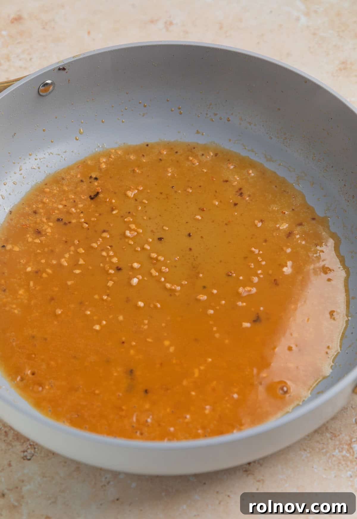 Rich Creamy Chicken Orzo 6 Broth and garlic added to skillet.