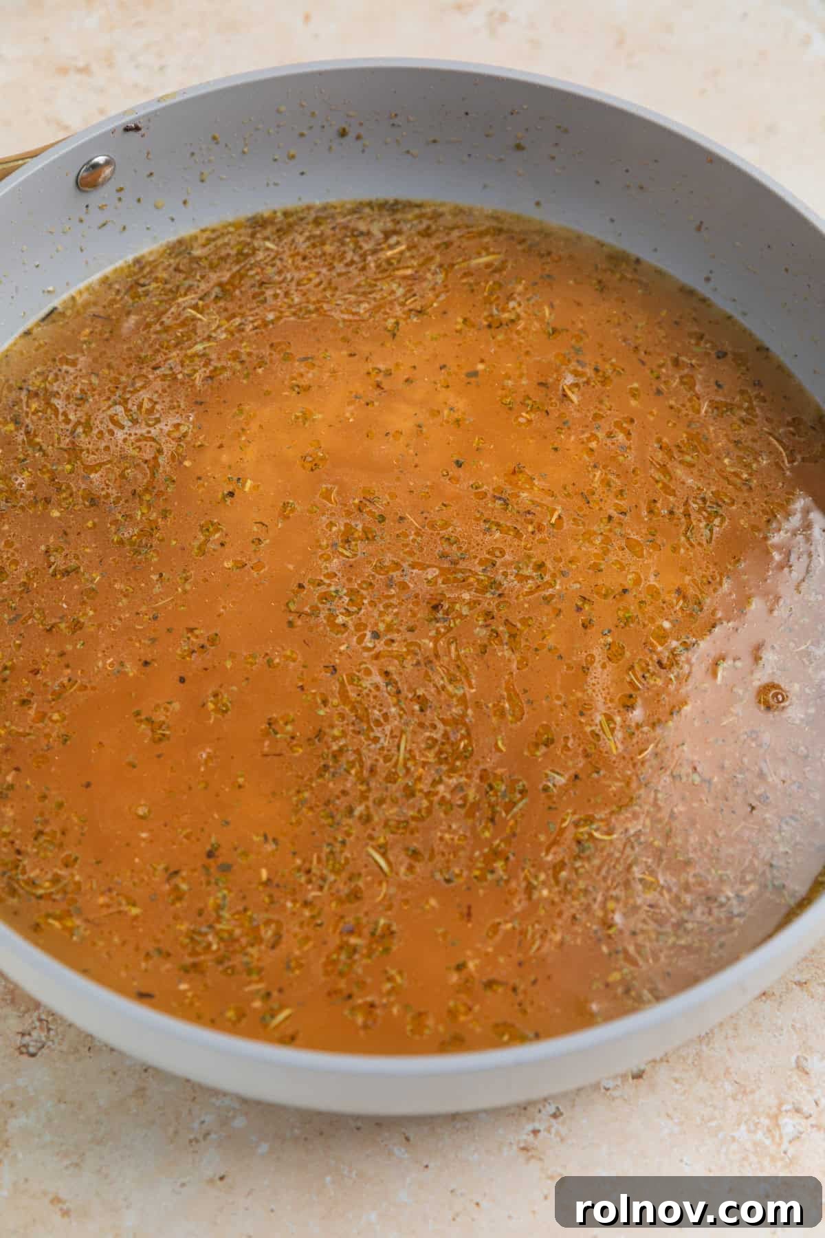 Rich Creamy Chicken Orzo 7 Skillet with broth and orzo before cooking.