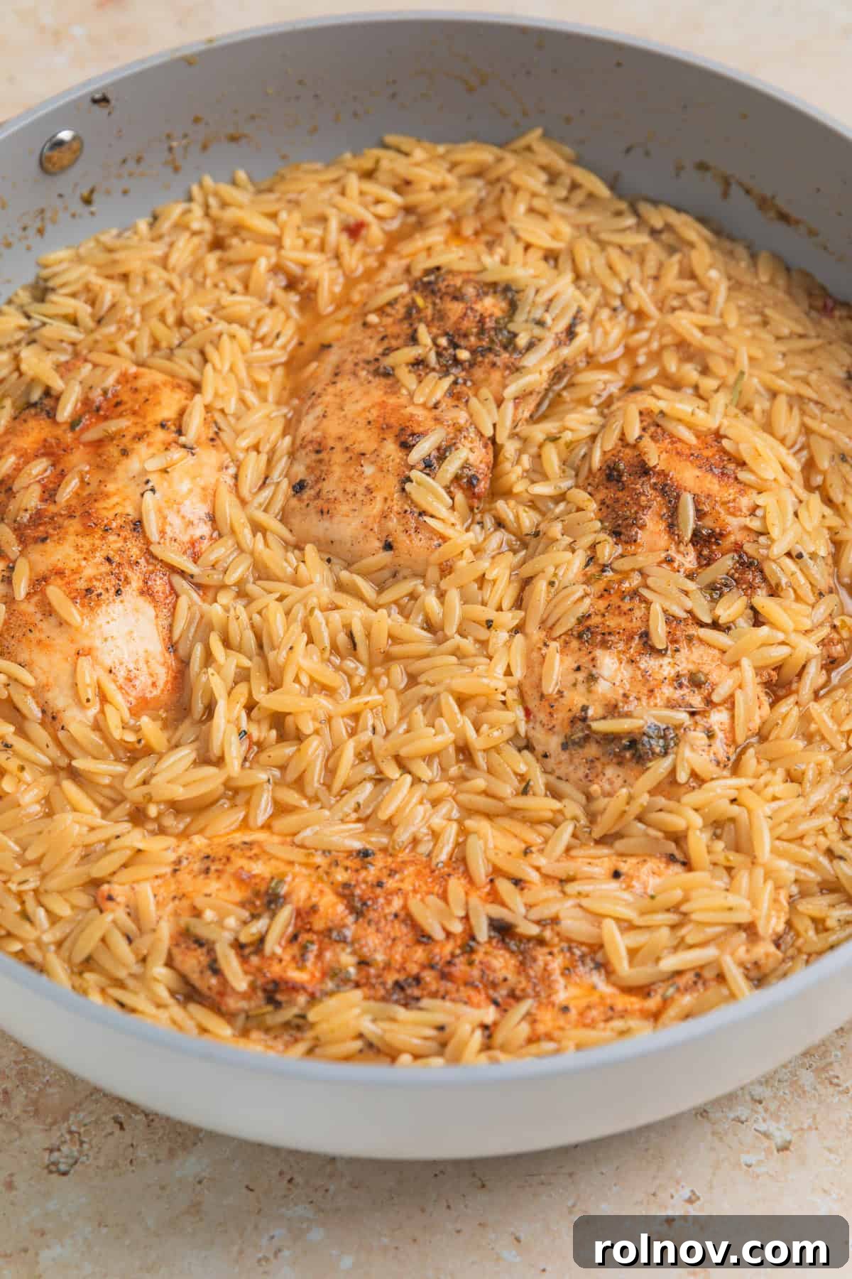 Rich Creamy Chicken Orzo 9 Cooked orzo in pan with chicken breast.