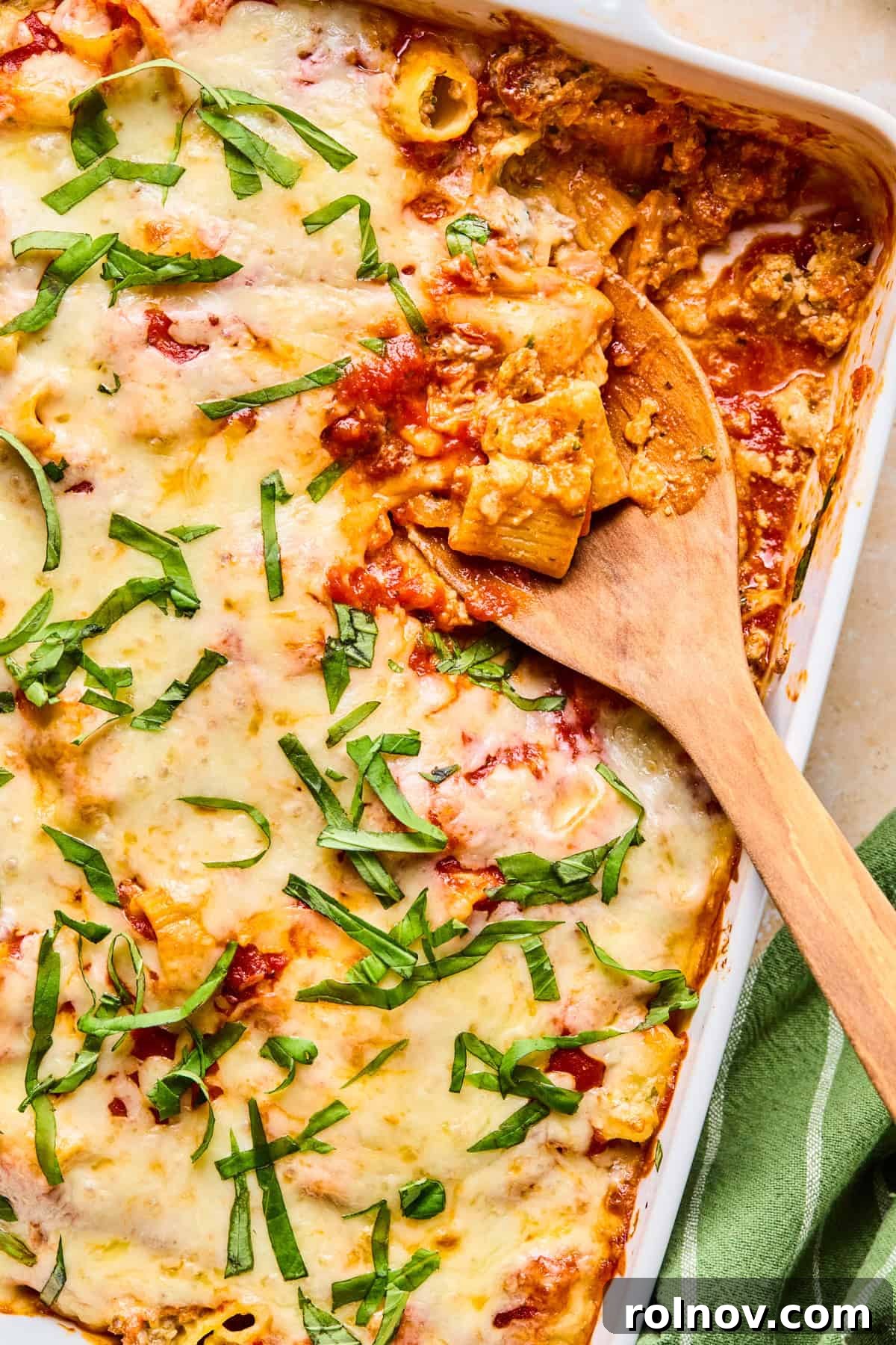 Rustic Italian Sausage Pasta Casserole 2 Pan with Italian sausage and ricotta pasta bake with spoon scooping in.