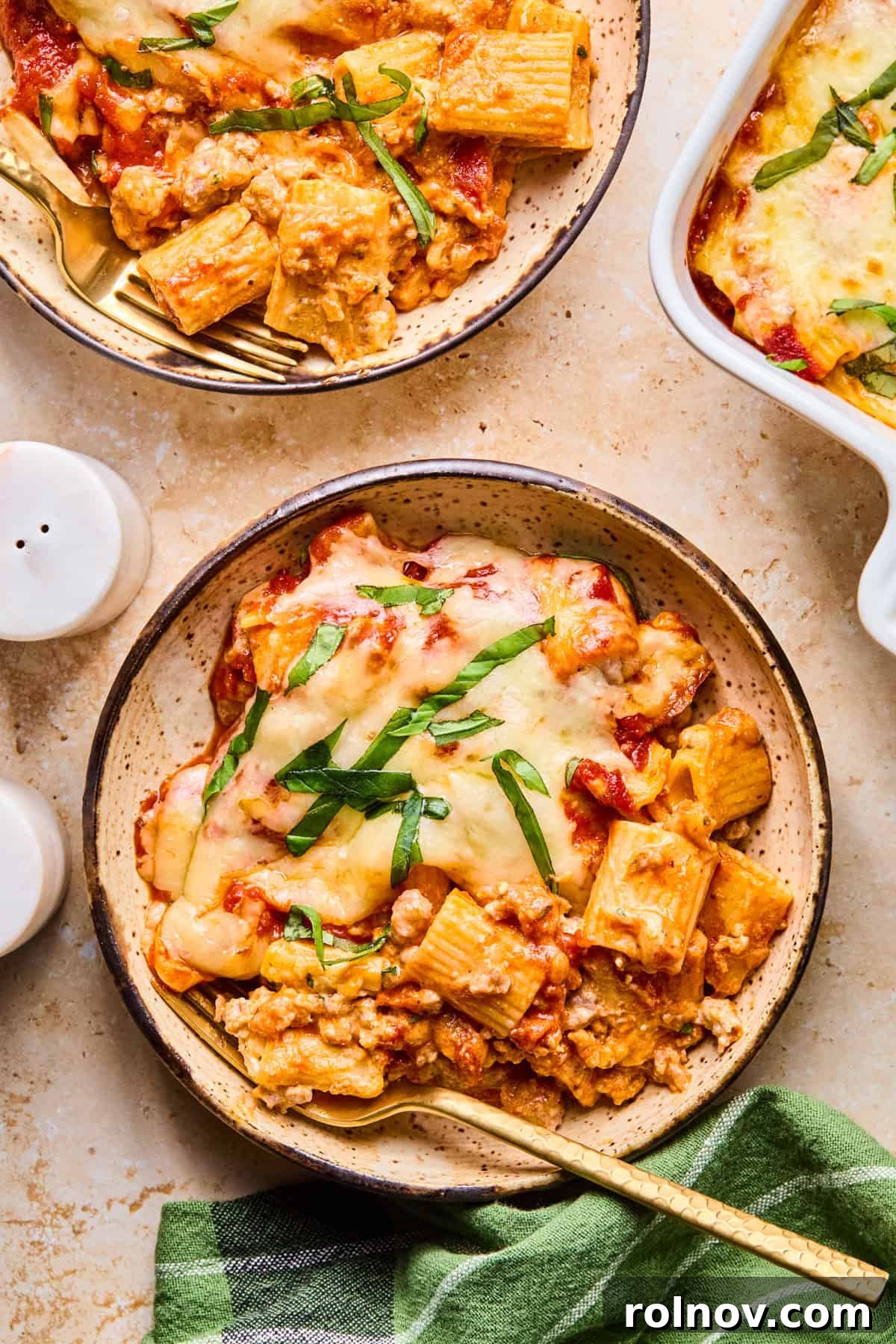 Rustic Italian Sausage Pasta Casserole 15 Bowl of baked pasta with fresh basil and melty mozzarella on top.