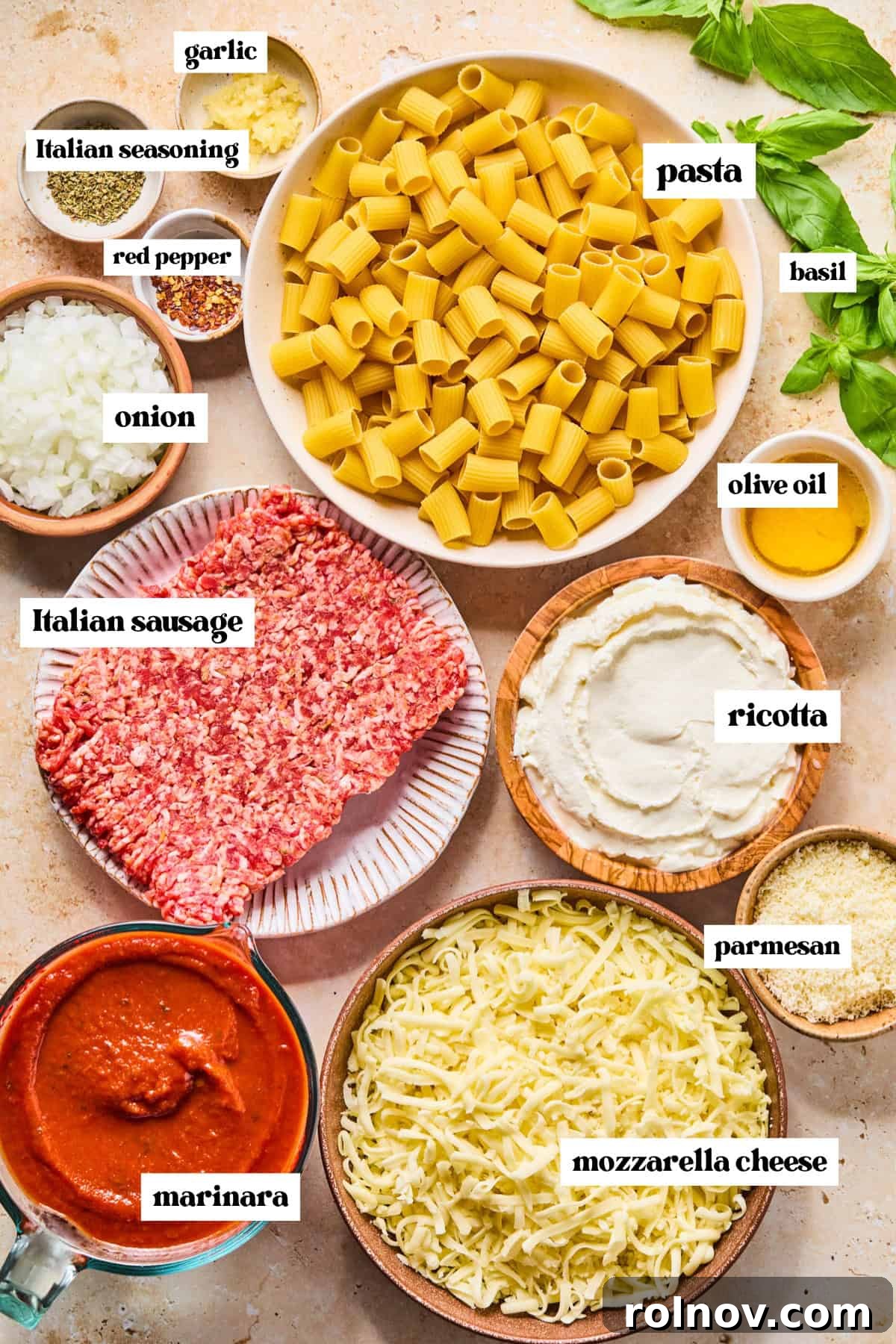 Rustic Italian Sausage Pasta Casserole 4 Pasta, meat, basil and other ingredients arranged on surface prepped for recipe.