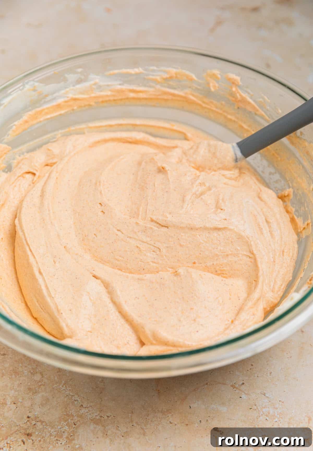 The complete no bake pumpkin cheesecake filling in a bowl, showing the combined texture after folding in the whipped cream, ready for the crust.