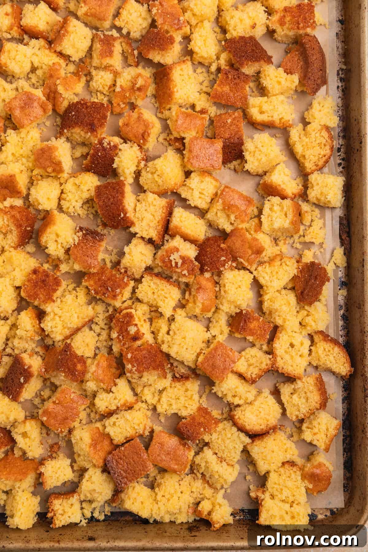 Southern Beef Cornbread Dressing 4 Cubed cornbread on parchment lined cookie sheet.