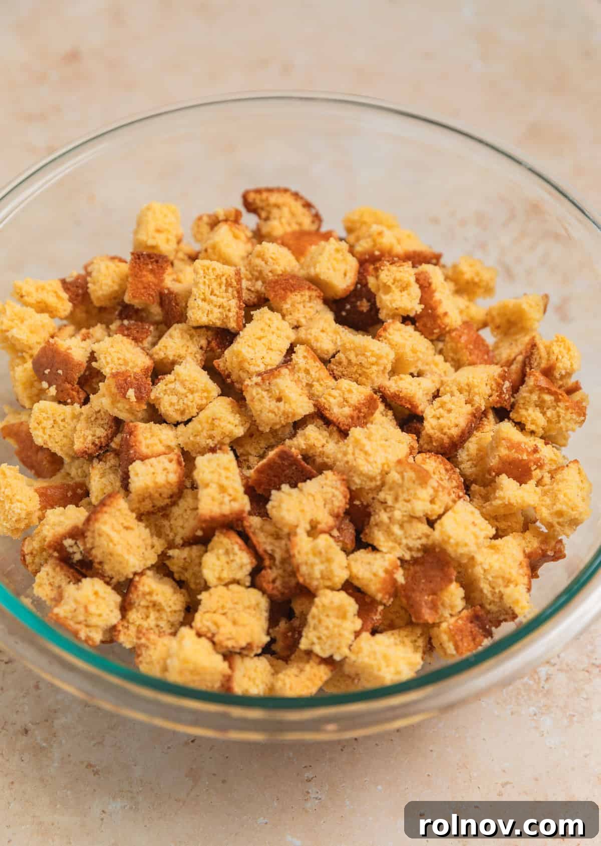 Southern Beef Cornbread Dressing 7 Glass mixing bowl with cornbread cubes.