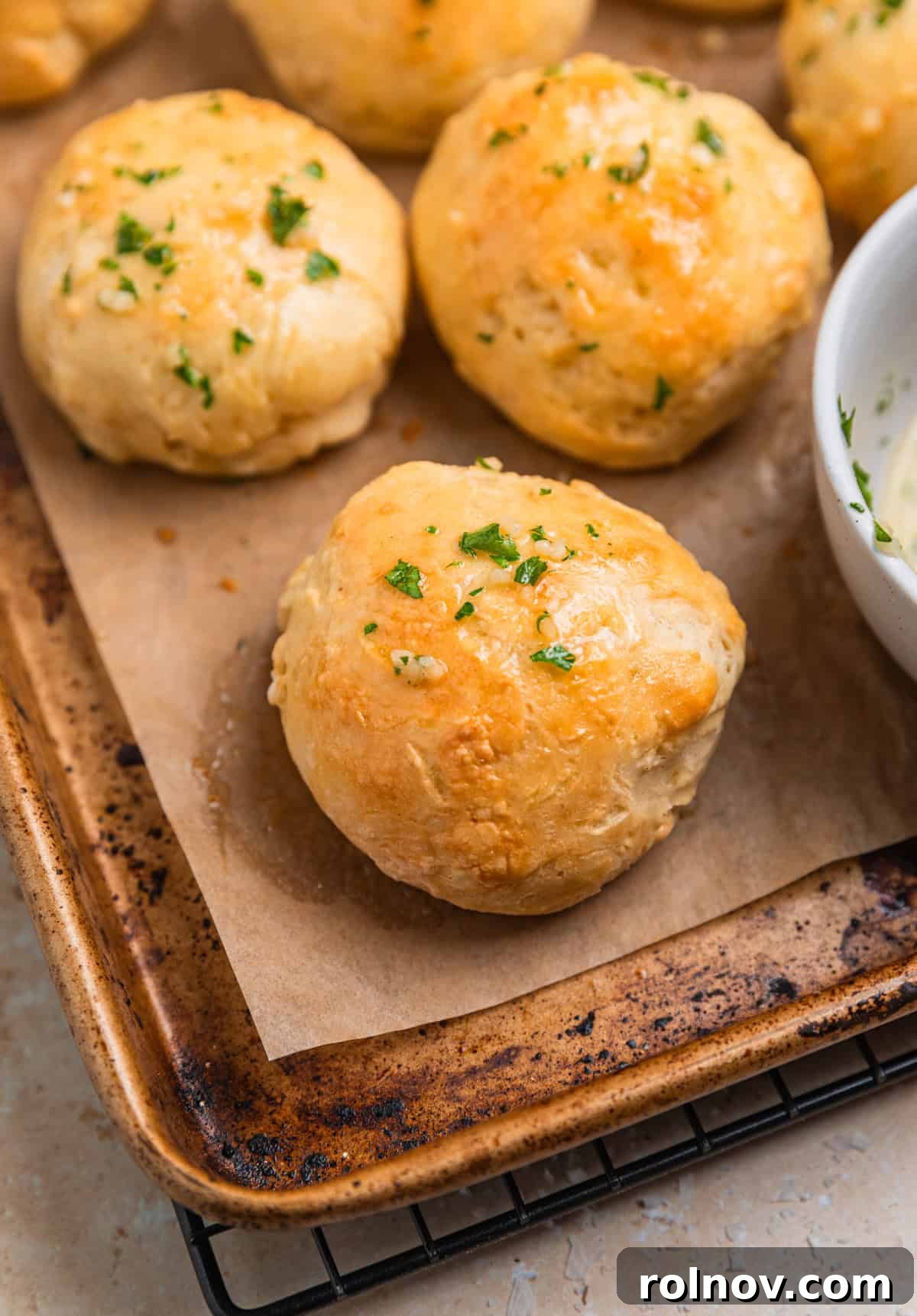 Sheet pan with dinner rolls made without yeast topped with garlic herb butter.