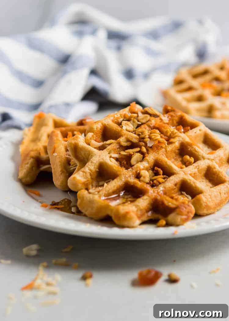 Rustic Carrot Cake Waffles 3 A close-up shot of golden-brown Whole Wheat Carrot Cake Waffles, drizzled with maple syrup and garnished with pecans, inviting a delicious breakfast.