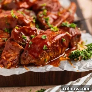 BBQ boneless pork ribs on wax paper lined cutting board topped with chopped fresh parsley.