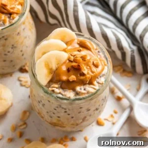 Glass jar with overnight oats topped with sliced banana and topped with peanut butter.