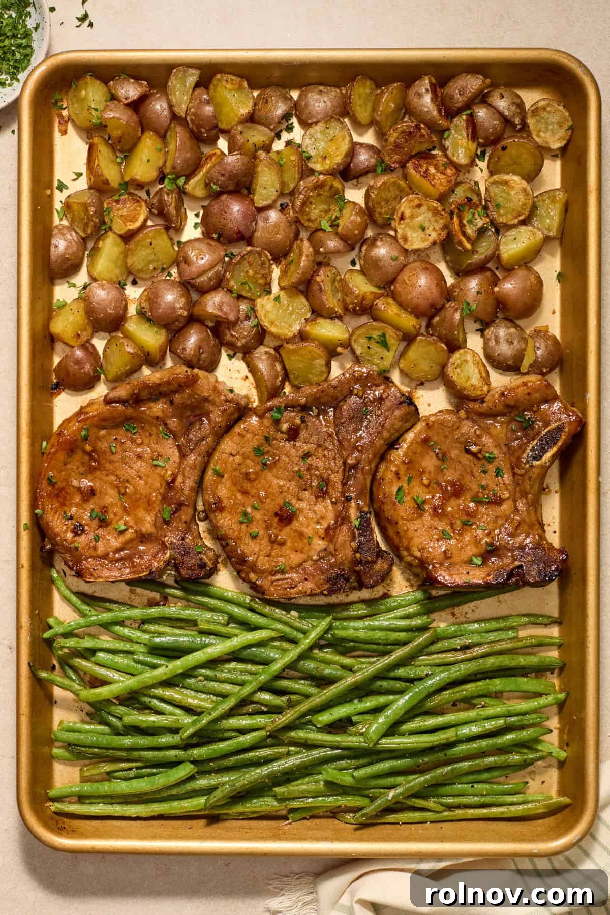 Quick & Flavorful Sheet Pan Pork Chops 2 Sheet pan dinner featuring golden-brown pork chops, crispy parmesan potatoes, and bright green beans, fresh from the oven and ready to serve.