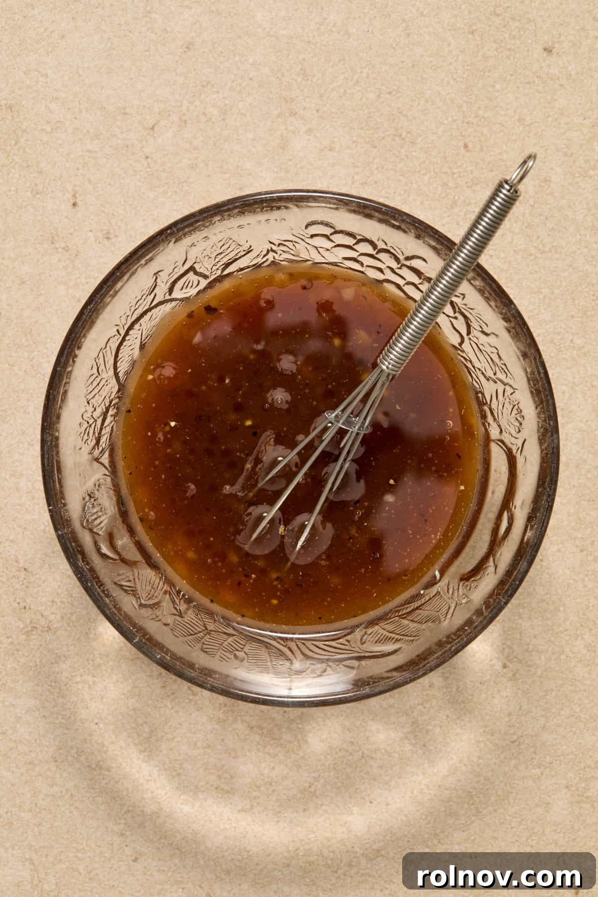 Quick & Flavorful Sheet Pan Pork Chops 3 Honey garlic balsamic marinade being thoroughly whisked in a small white bowl, ready for the pork chops.
