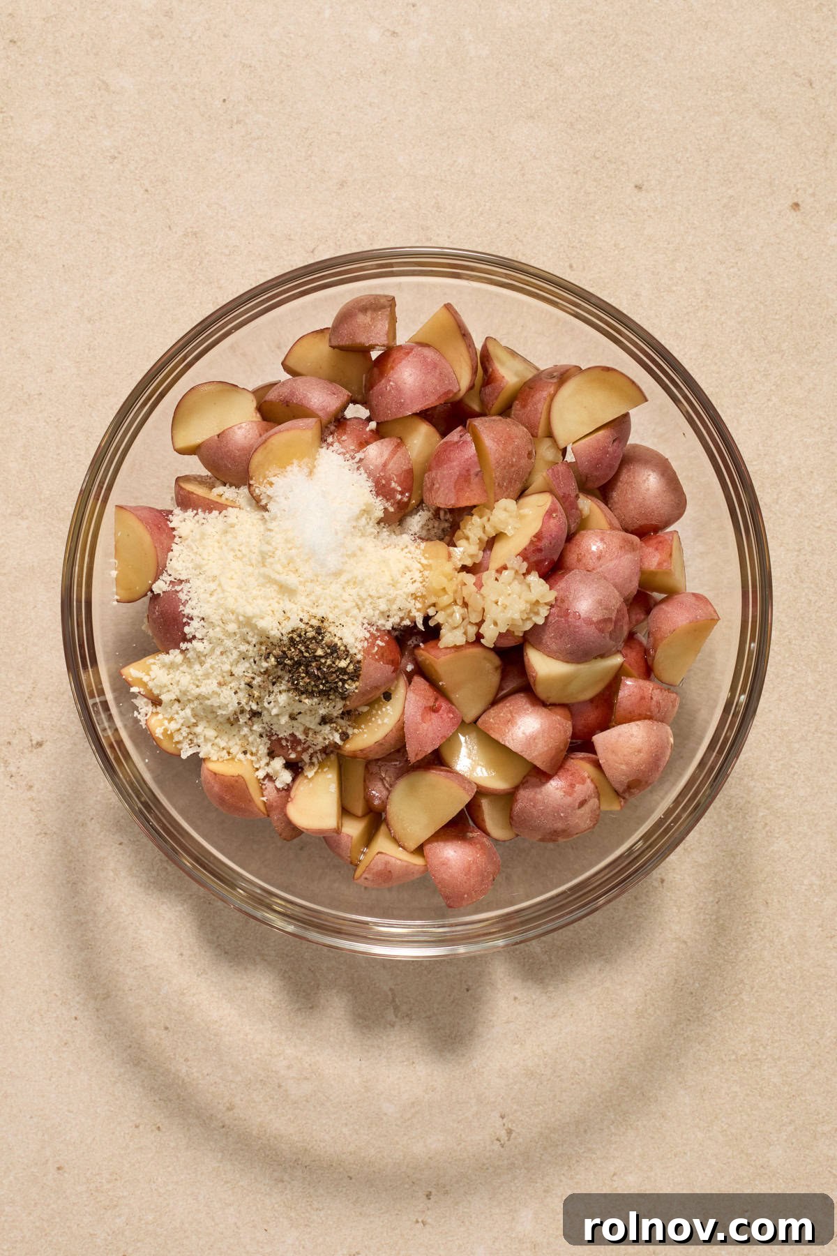 Quick & Flavorful Sheet Pan Pork Chops 5 Quartered petite potatoes in a mixing bowl, generously coated with grated parmesan, olive oil, minced garlic, salt, and pepper.