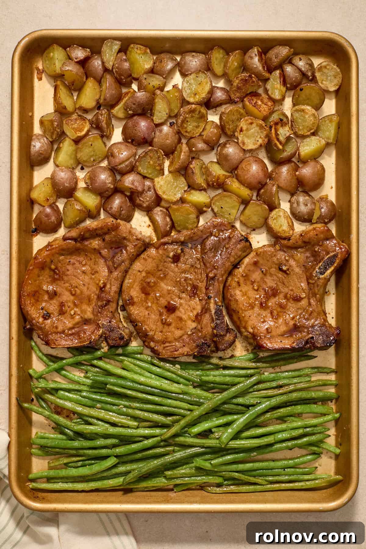 Quick & Flavorful Sheet Pan Pork Chops 10 Finished sheet pan dinner with beautifully cooked pork chops, golden roasted potatoes, and bright green beans, ready for resting.