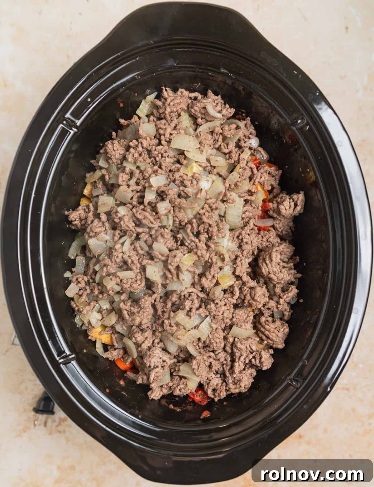 Hearty Slow Cooker Ground Beef Soup 5 Ground beef and sautéed onions added to crockpot with other hamburger soup ingredients before cooking.