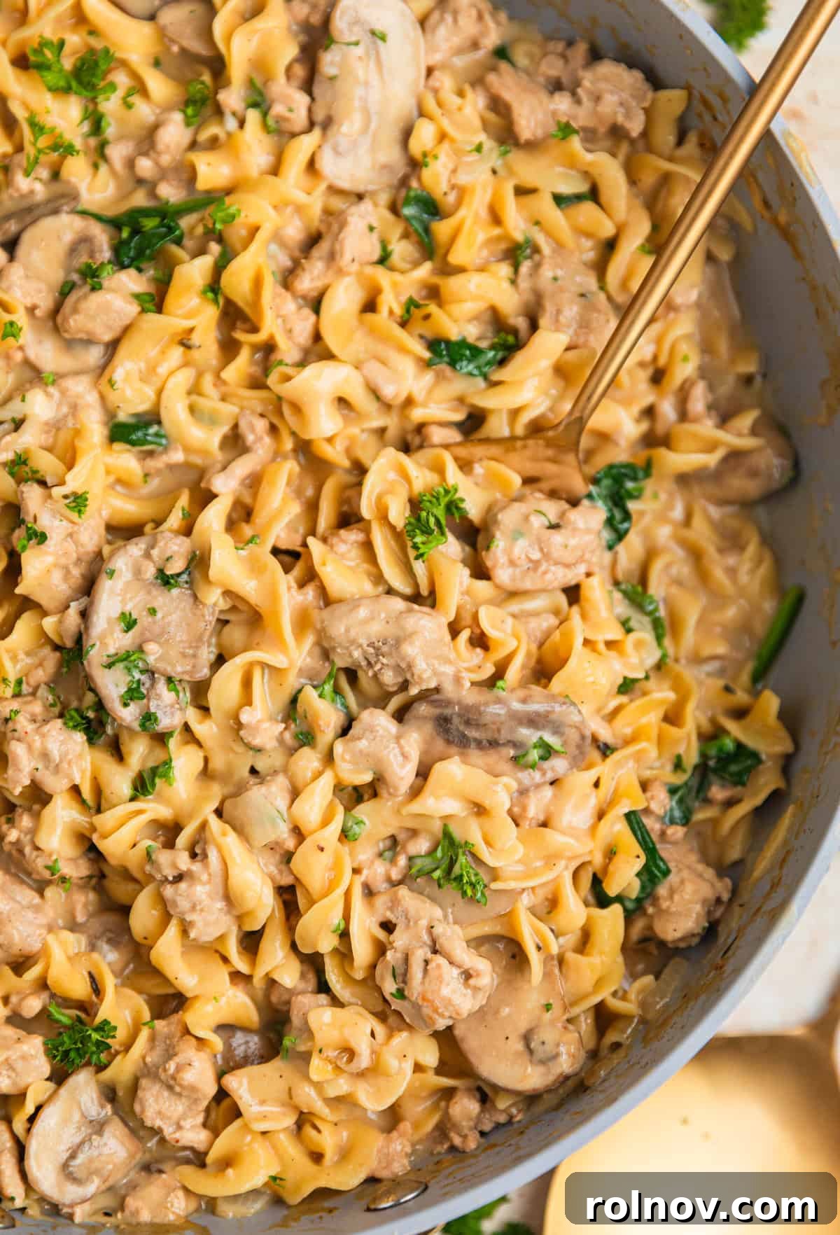 Creamy Ground Turkey Stroganoff 2 Skillet with ground turkey stroganoff with spoon scooping into the dish.