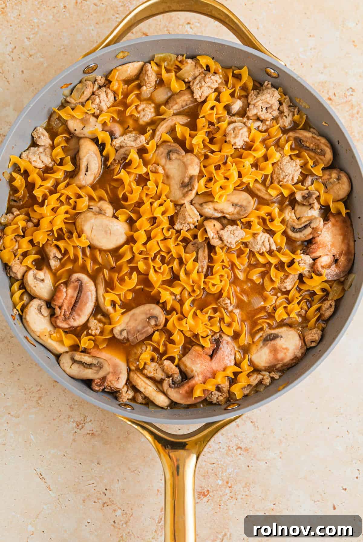 Creamy Ground Turkey Stroganoff 7 Broth and egg noodles added to skillet with meat and onions.