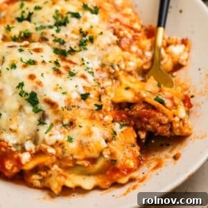 One-Pan Ravioli Lasagna 12 Skillet lasagna made with ravioli on plate with fork scooping up a forkful.