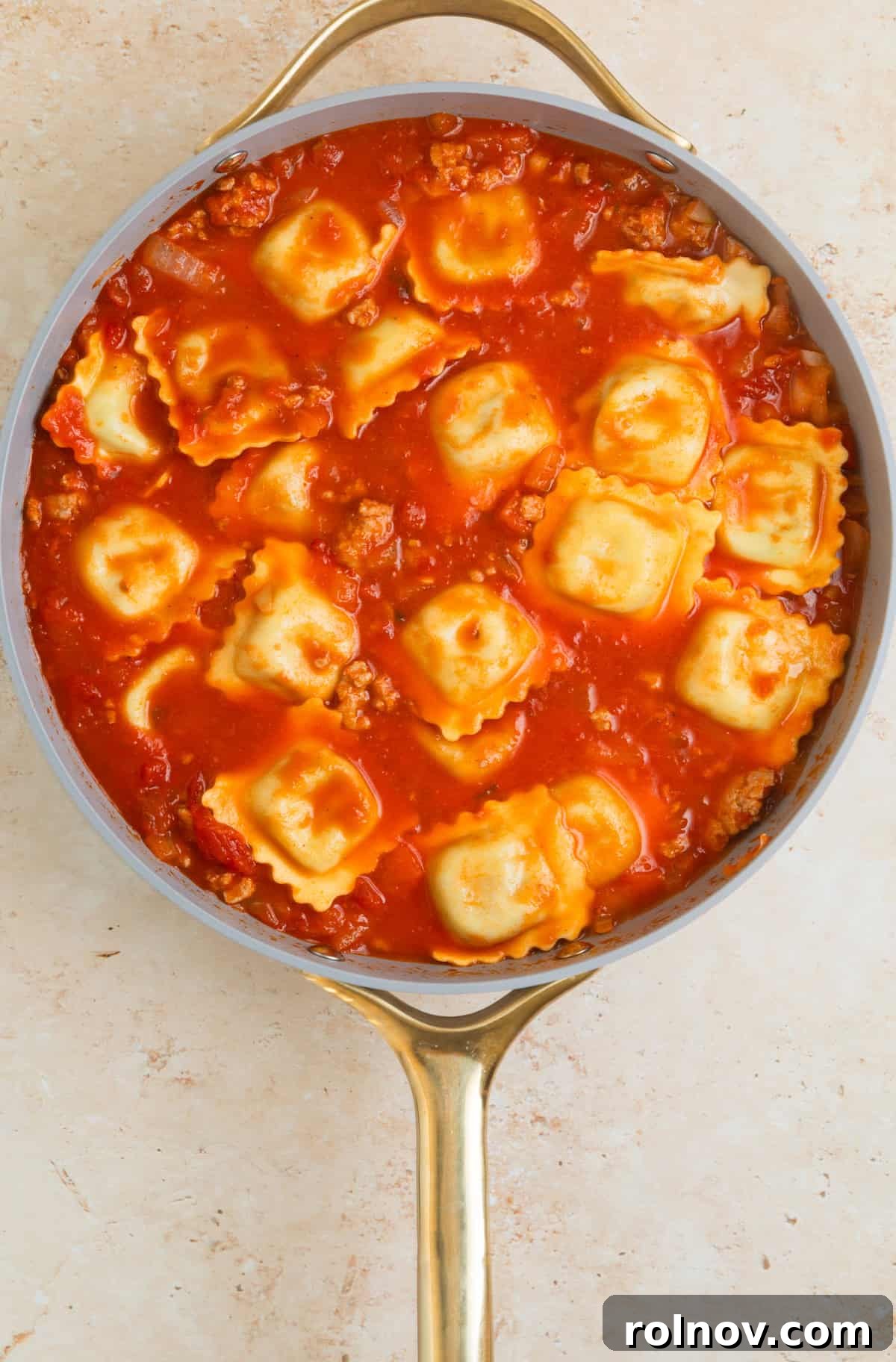 One-Pan Ravioli Lasagna 8 Lasagna added to skillet with meat and tomato sauce.