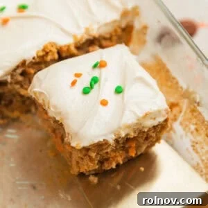 Foolproof Box Mix Carrot Cake 13 Slice of carrot cake with cream cheese frosting on spatula being pulled from the rest of the cake.