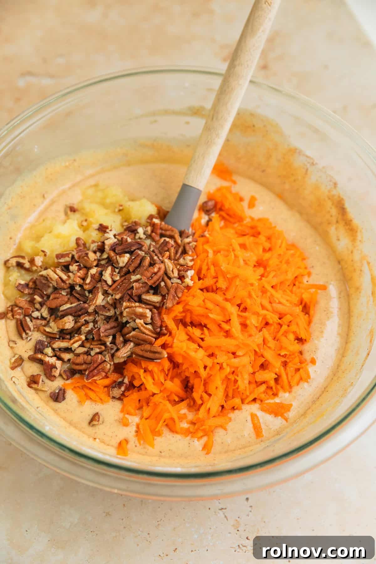 Foolproof Box Mix Carrot Cake 6 Shredded carrots, chopped pecans, and crushed pineapple added to the cake batter in a bowl, awaiting gentle folding.