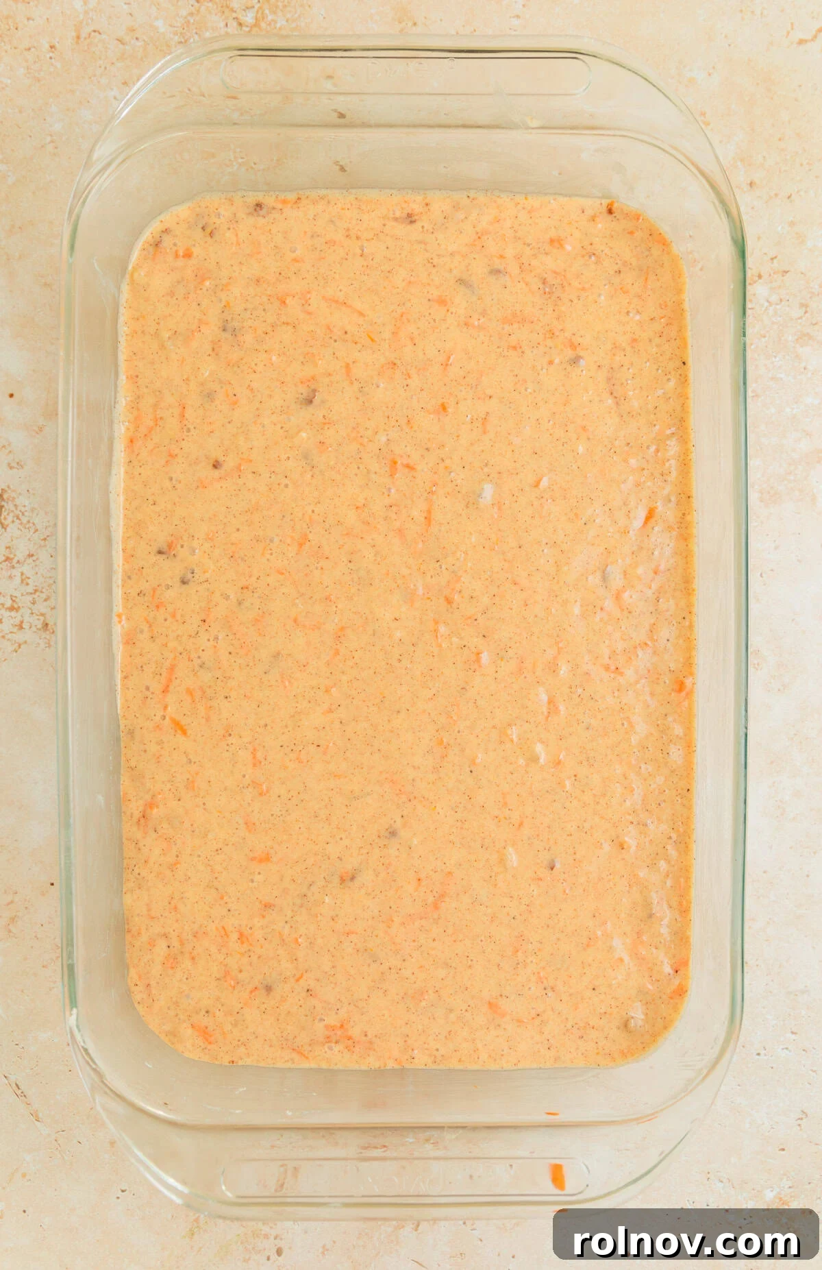 Foolproof Box Mix Carrot Cake 8 Carrot cake batter evenly spread in a well-greased glass baking pan, ready to go into the oven.