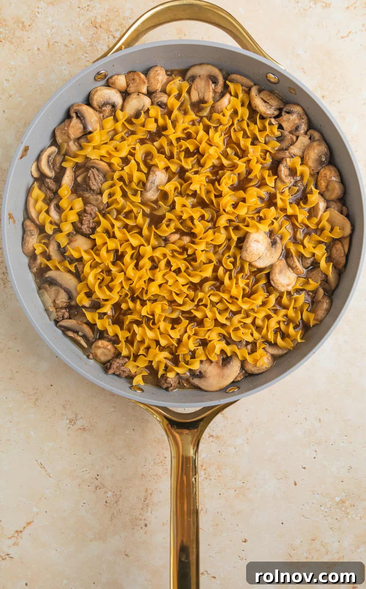 Creamy One-Pot Ground Beef Stroganoff 7 Wide egg noodles added to skillet with ground beef stroganoff.