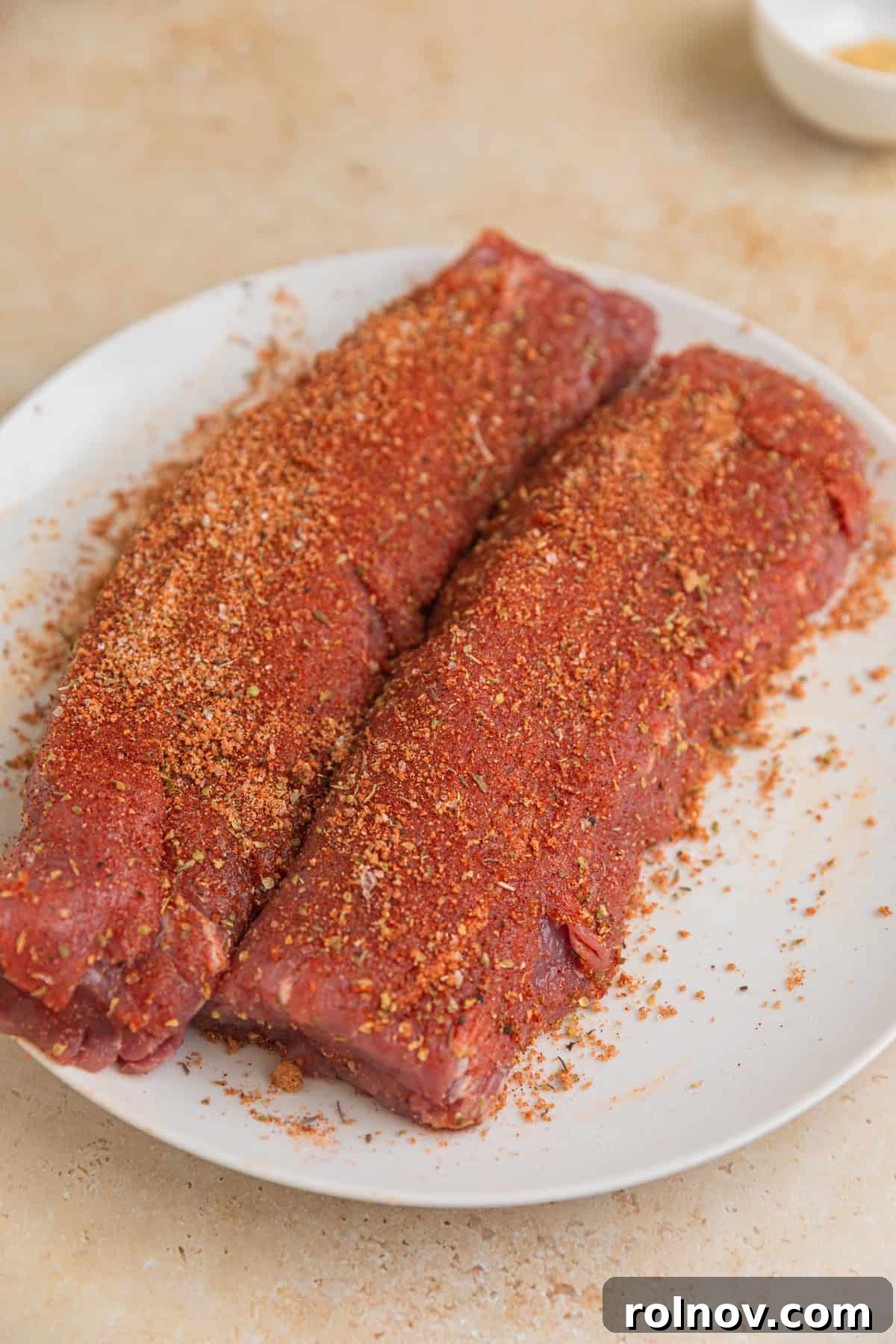 Seared Pork Tenderloin with Dijon Cream 5 Pork tenderloin on plate with spice rub covering it.