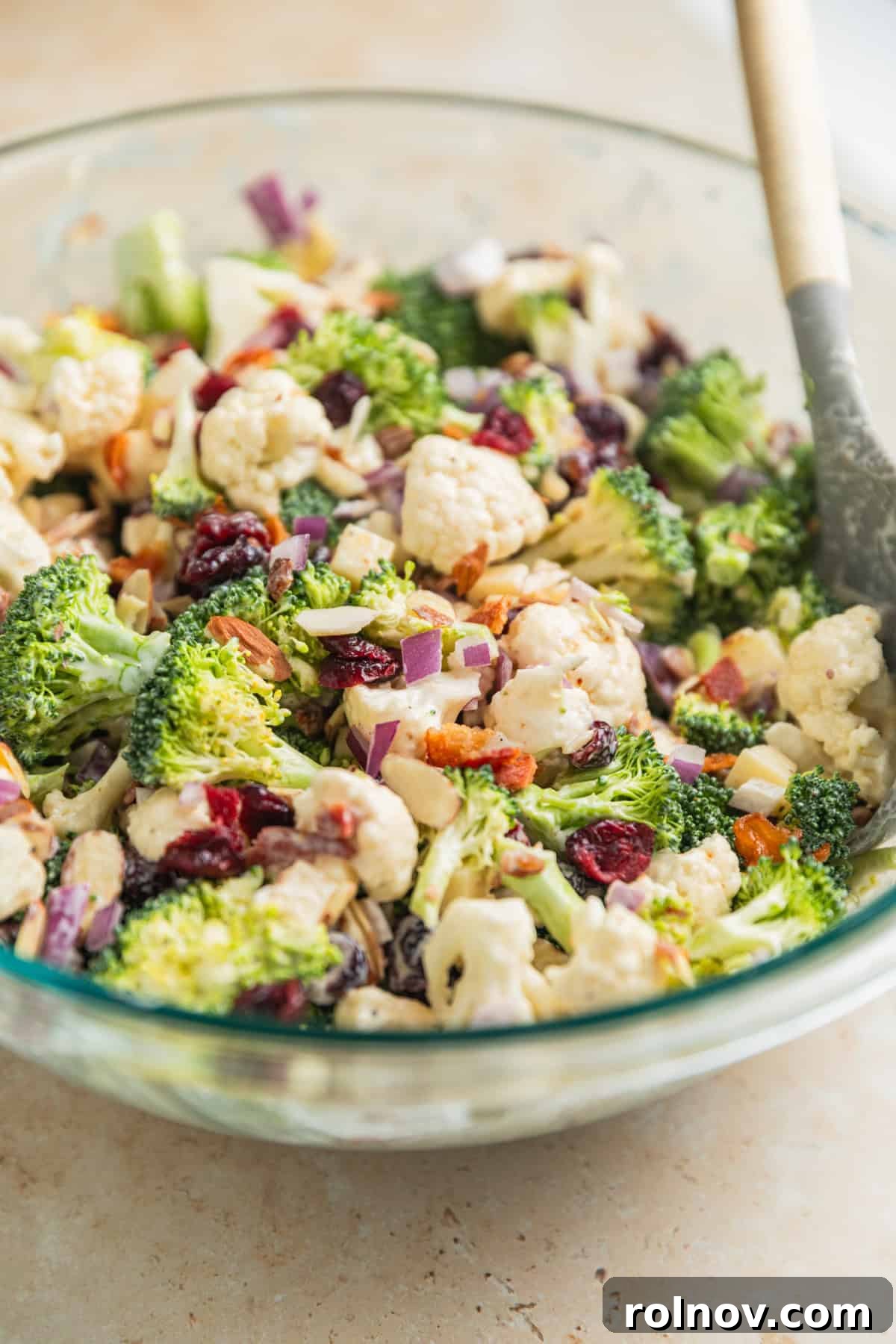 Vibrant Broccoli Cauliflower Medley 8 The fully dressed broccoli and cauliflower salad in a large mixing bowl, with a serving spoon resting inside, ready for chilling or serving.