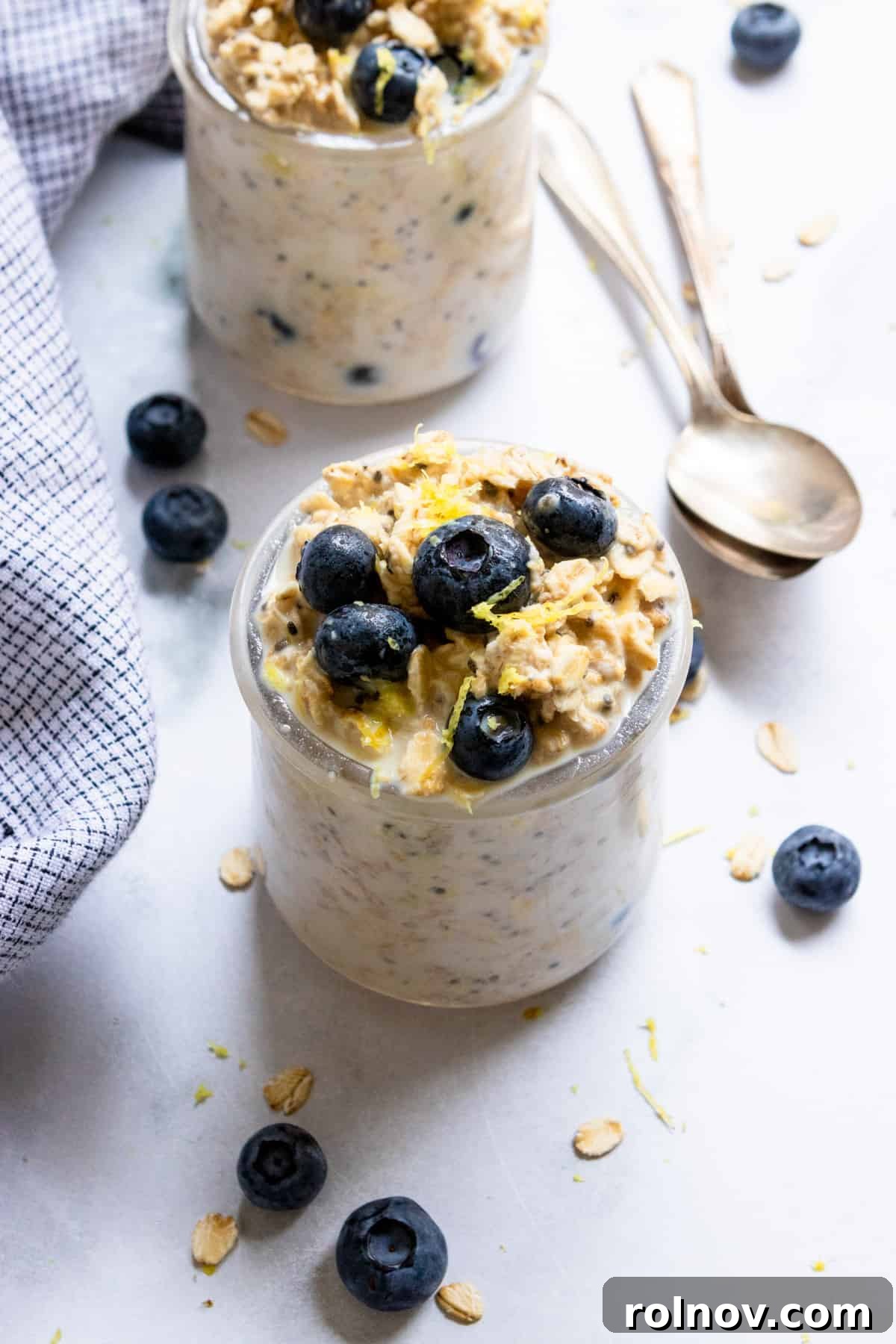 Blueberry lemon overnight oats in jar with lemon zest and fresh blueberries.