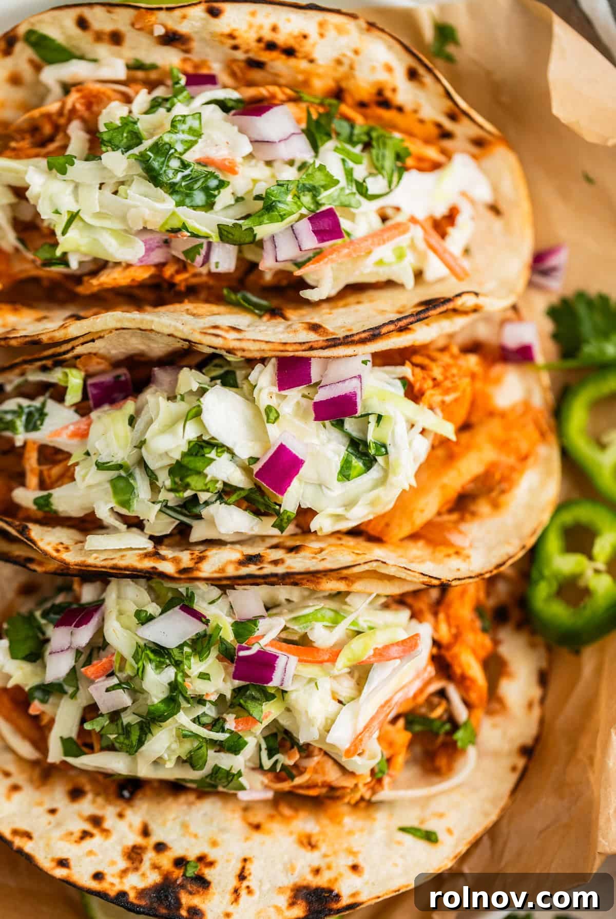 Fall-Apart BBQ Chicken Tacos with Zesty Slaw 2 Crockpot bbq chicken tacos lined up and topped with slaw.