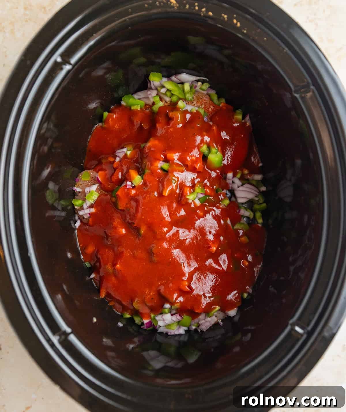 Fall-Apart BBQ Chicken Tacos with Zesty Slaw 4 Chopped pepper and onions over seasoned chicken breast topped with barbecue sauce in crockpot before cooking.