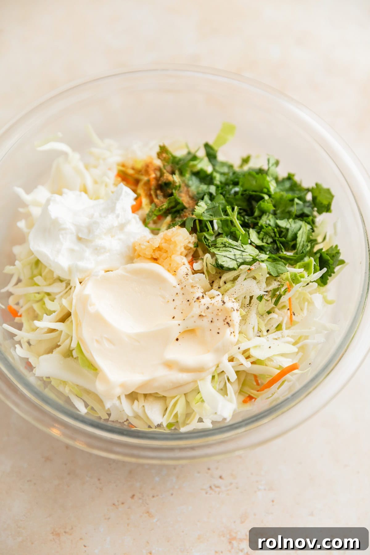 Fall-Apart BBQ Chicken Tacos with Zesty Slaw 7 Cabbage, mayo, sour cream, and other ingredients in glass mixing bowl.