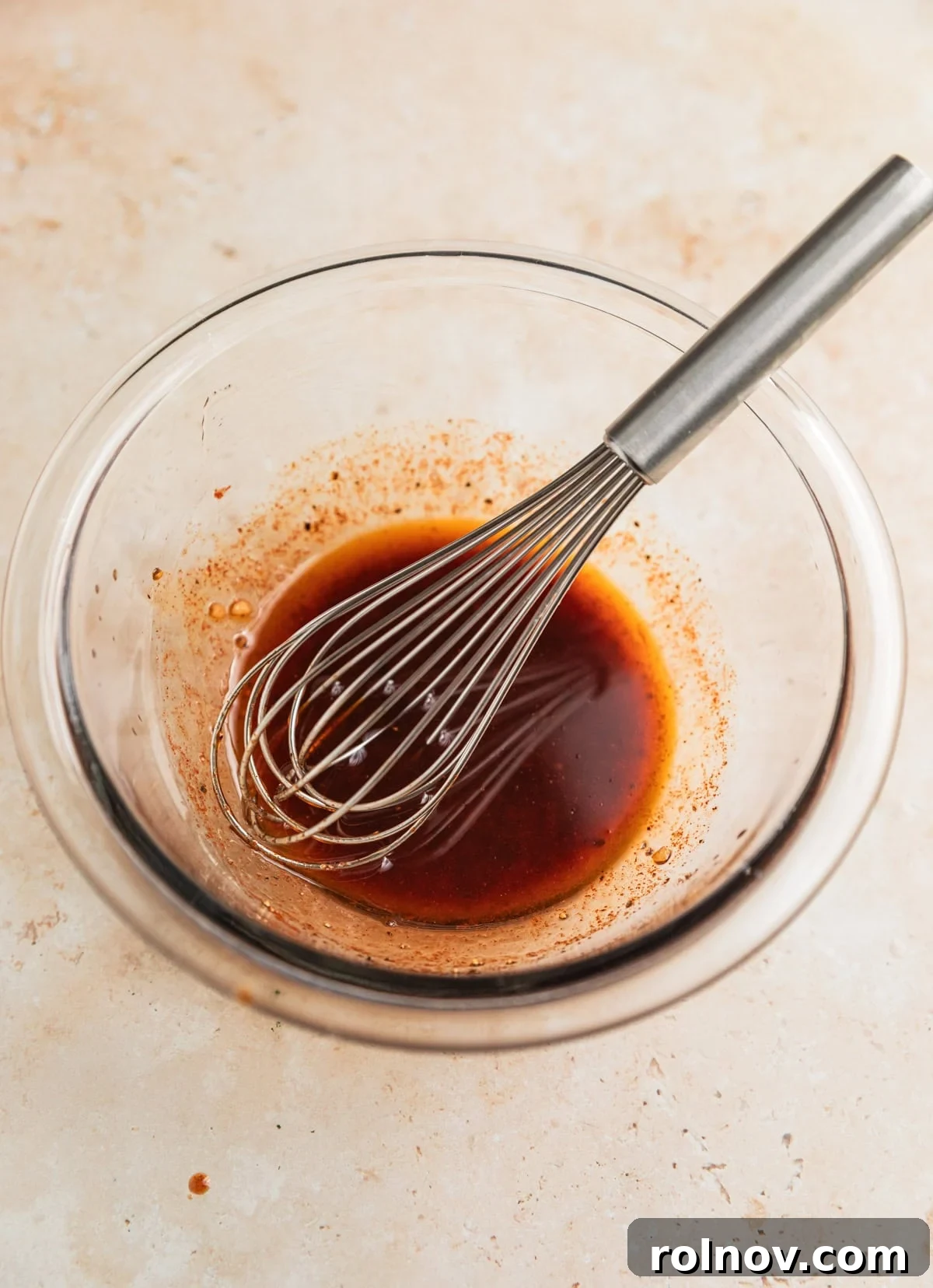 Crispy Air Fryer Salmon Bites 4 Salmon marinade in glass bowl with whisk.