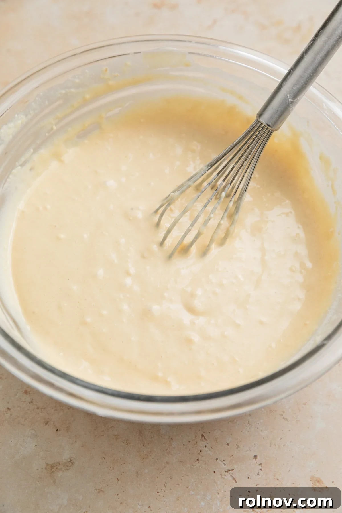 Cottage Cloud Waffles 5 Cottage cheese waffle batter in a bowl with a whisk, showing a thick but pourable consistency.