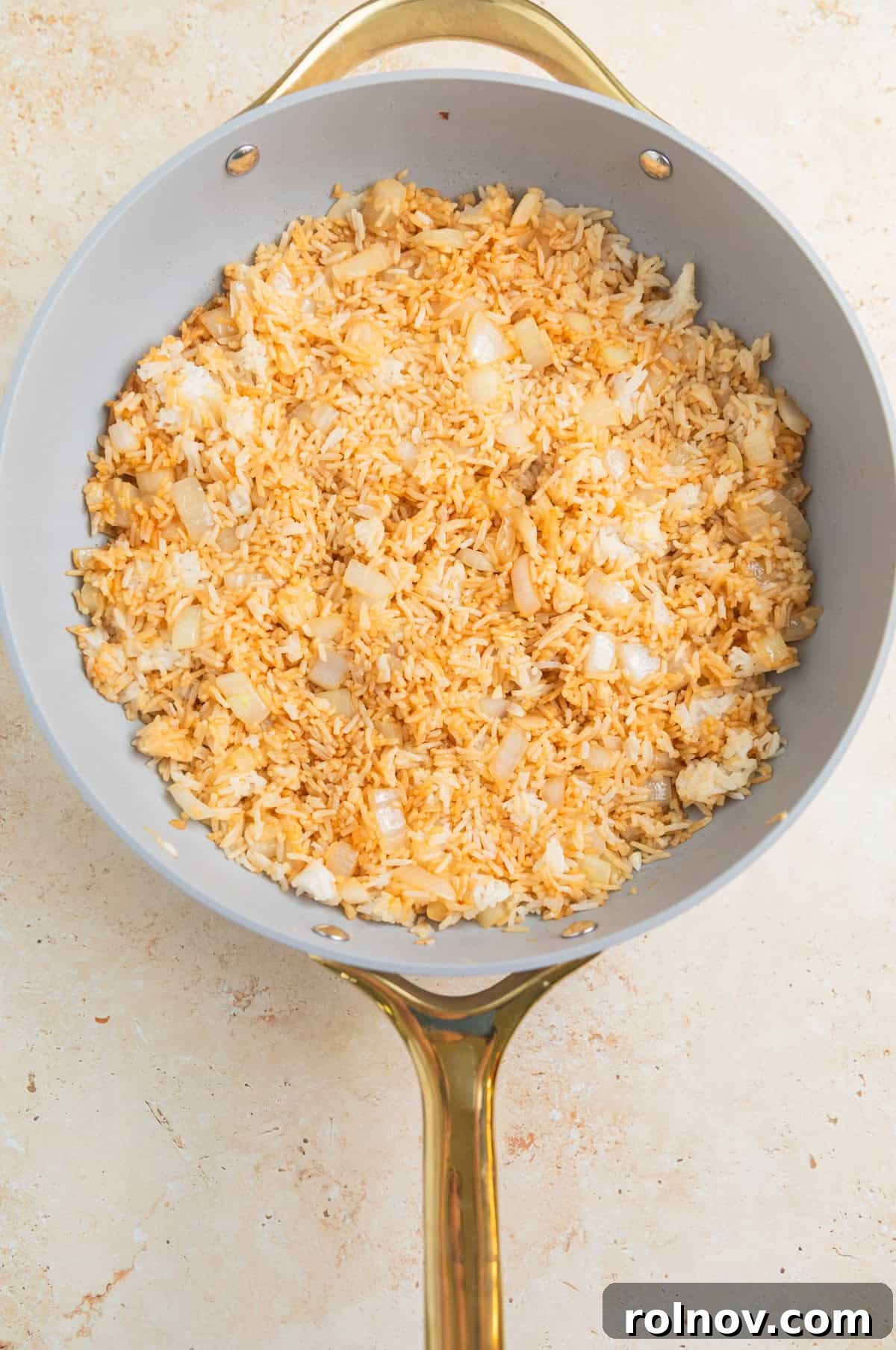 Quick Homestyle Chicken Fried Rice 6 Cooked rice being stir-fried in a skillet with soy sauce and sesame oil.