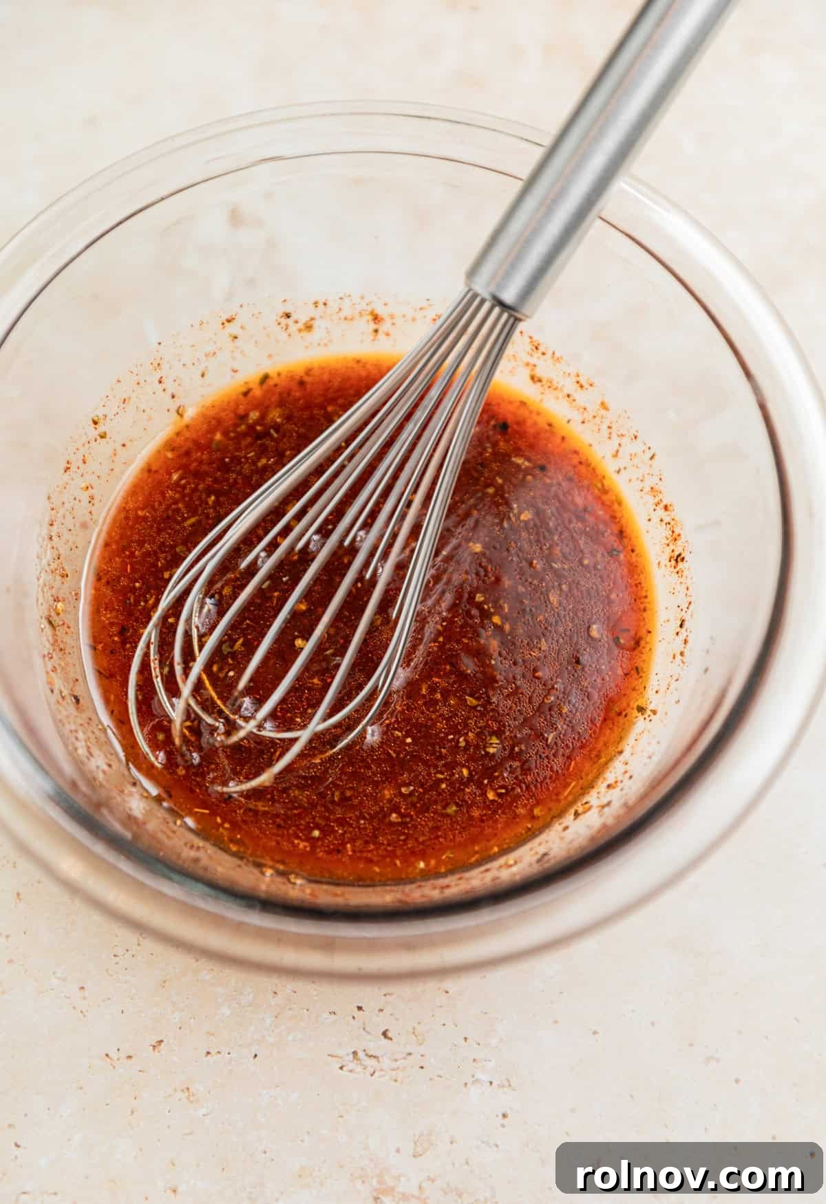 Chili lime marinade in glass mixing bowl with whisk.