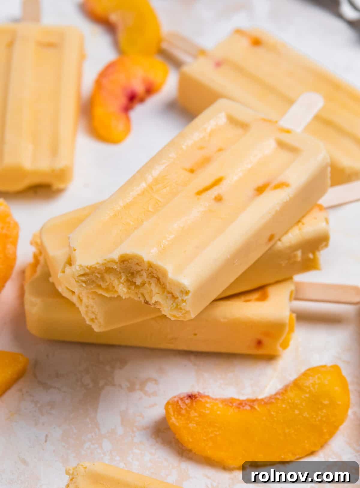 Peaches & Cream Pops 2 Stacked creamy peach popsicles with bite taken out of top popsicle.