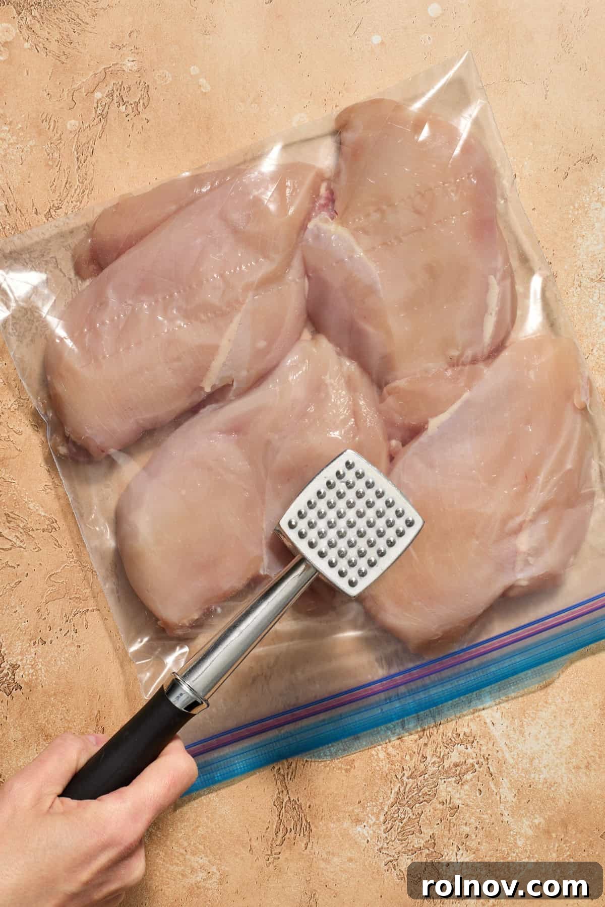 Grilled Balsamic Glazed Chicken Breast 4 Chicken breast in plastic bag being pounded with meat tenderizer.
