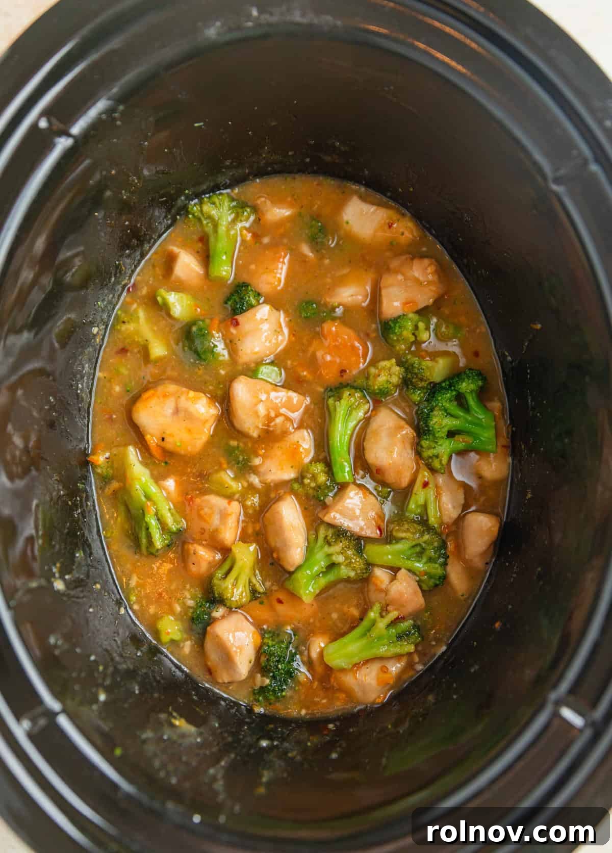 Zesty Slow Cooker Orange Chicken 11 A close-up view of the finished slow cooker orange chicken and broccoli, bathed in a rich sauce, ready to be served.