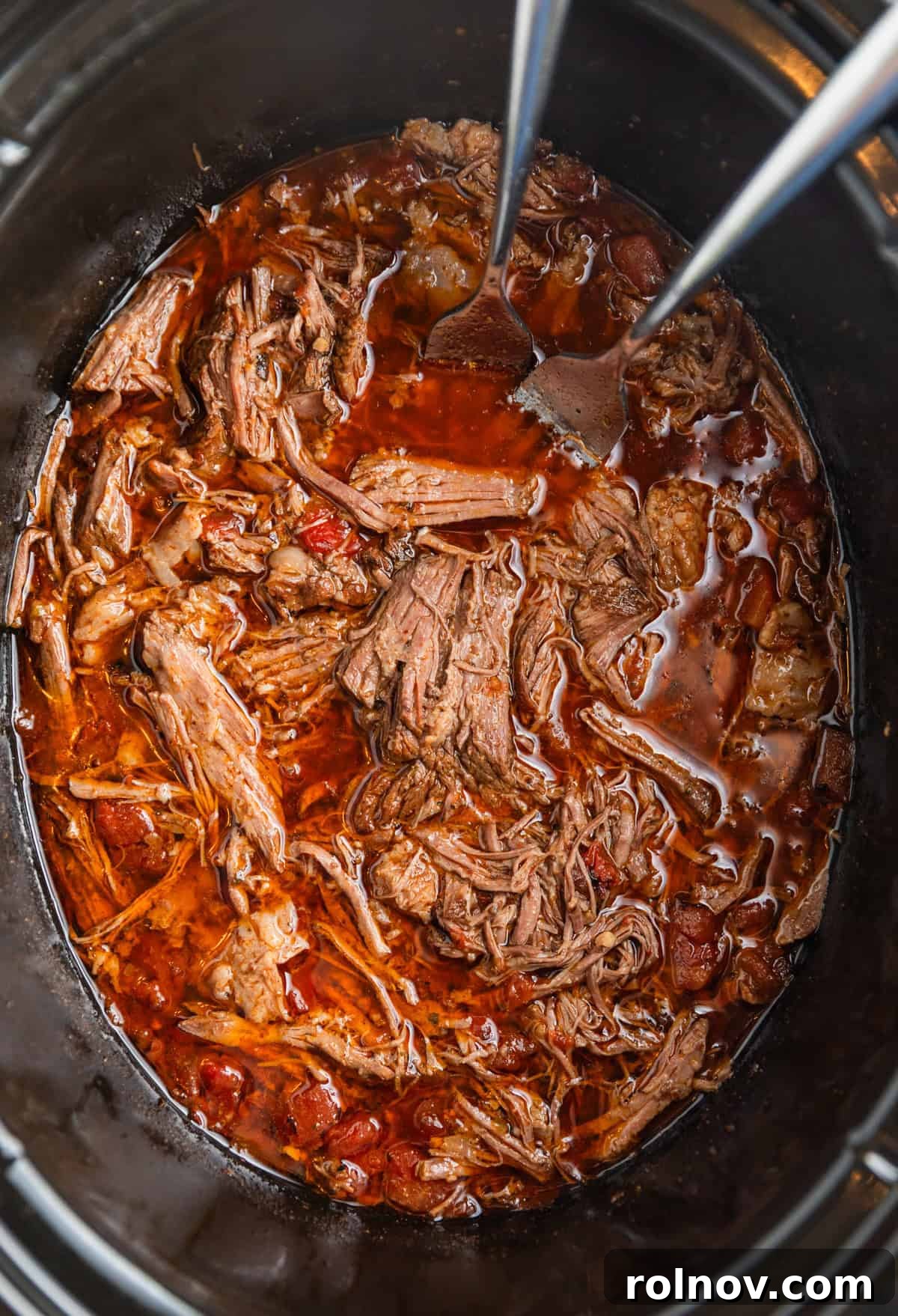 Melt In Your Mouth Slow Cooker Beef Tacos 8 Shredded beef tacos in crock pot with forks.