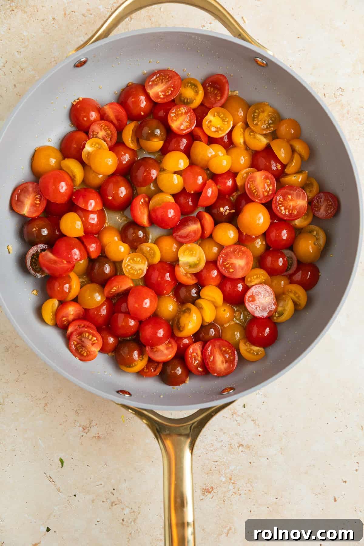 Sun-Kissed Cherry Tomato Delight 5 Halved cherry tomatoes freshly added to the pan, mingling with sautéed olive oil and garlic, beginning to cook down into a vibrant sauce.