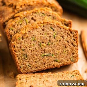 Grandmas Zucchini Bread Perfected 16 Beautifully stacked slices of golden zucchini bread on parchment paper.