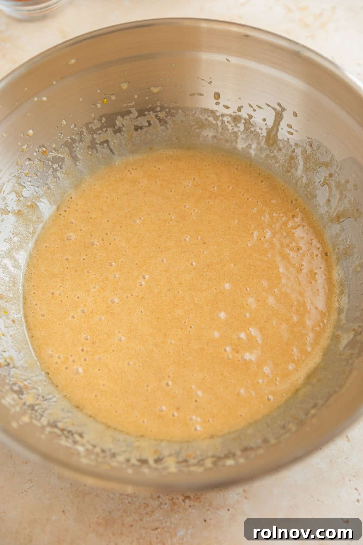 Grandmas Zucchini Bread Perfected 6 A smooth, emulsified mixture of beaten eggs, sugars, oil, and vanilla extract in a large bowl.