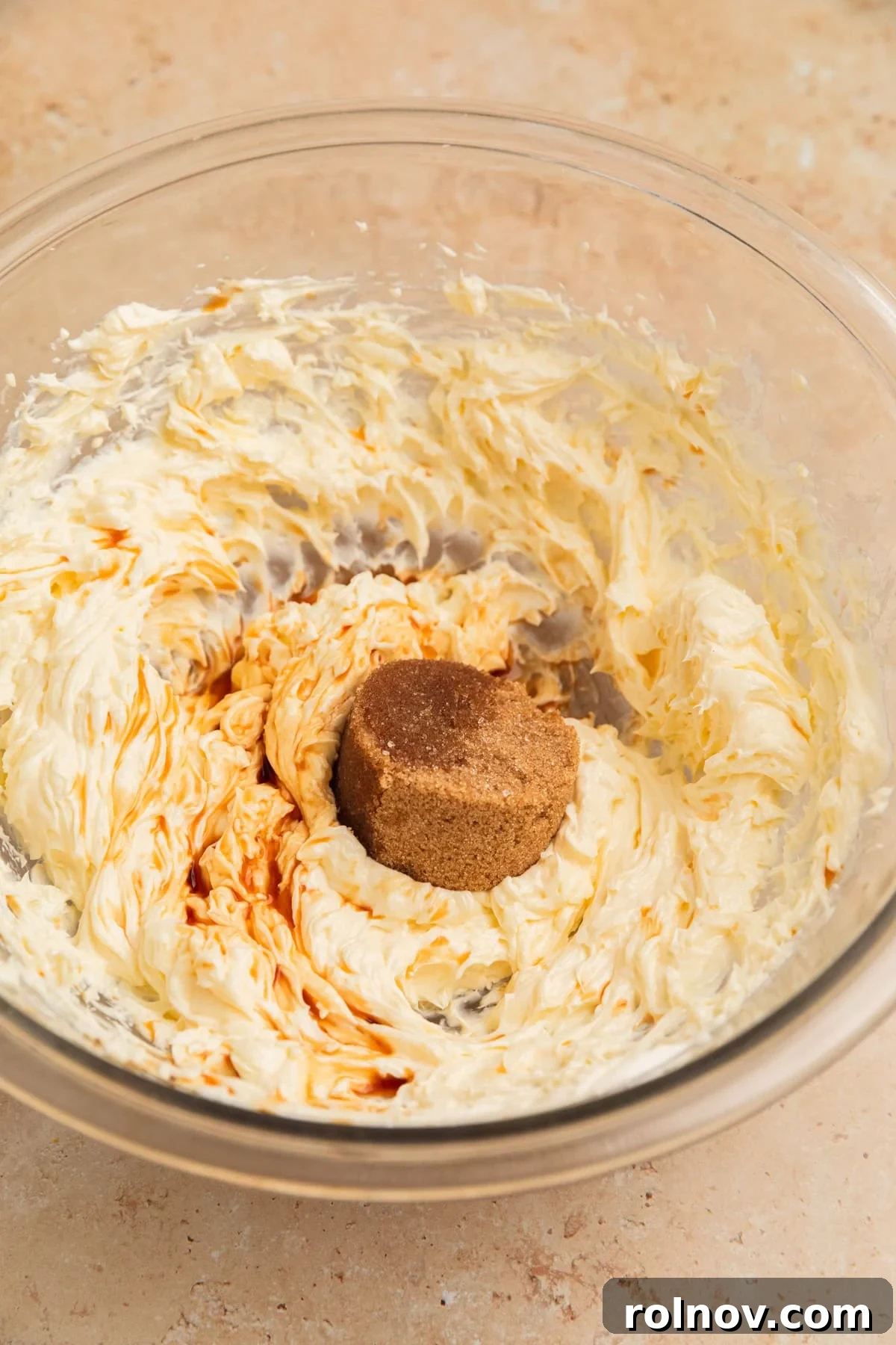 Effortless Cake Mix Pumpkin Bread 12 Cream cheese and butter perfectly creamed in a mixing bowl, with brown sugar and vanilla extract being added for the frosting.
