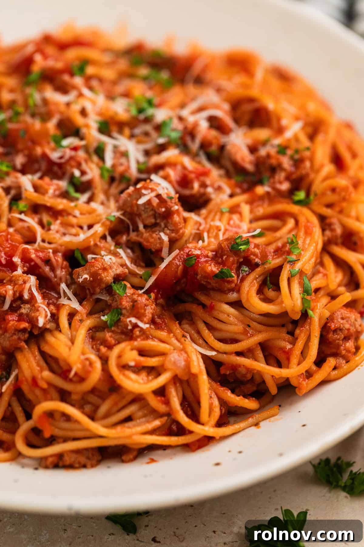 One-Pot Wonder Spaghetti 2 A vibrant plate of Instant Pot spaghetti topped with savory meat sauce, fresh chopped parsley, and a generous sprinkle of freshly grated Parmesan cheese, ready to be enjoyed.
