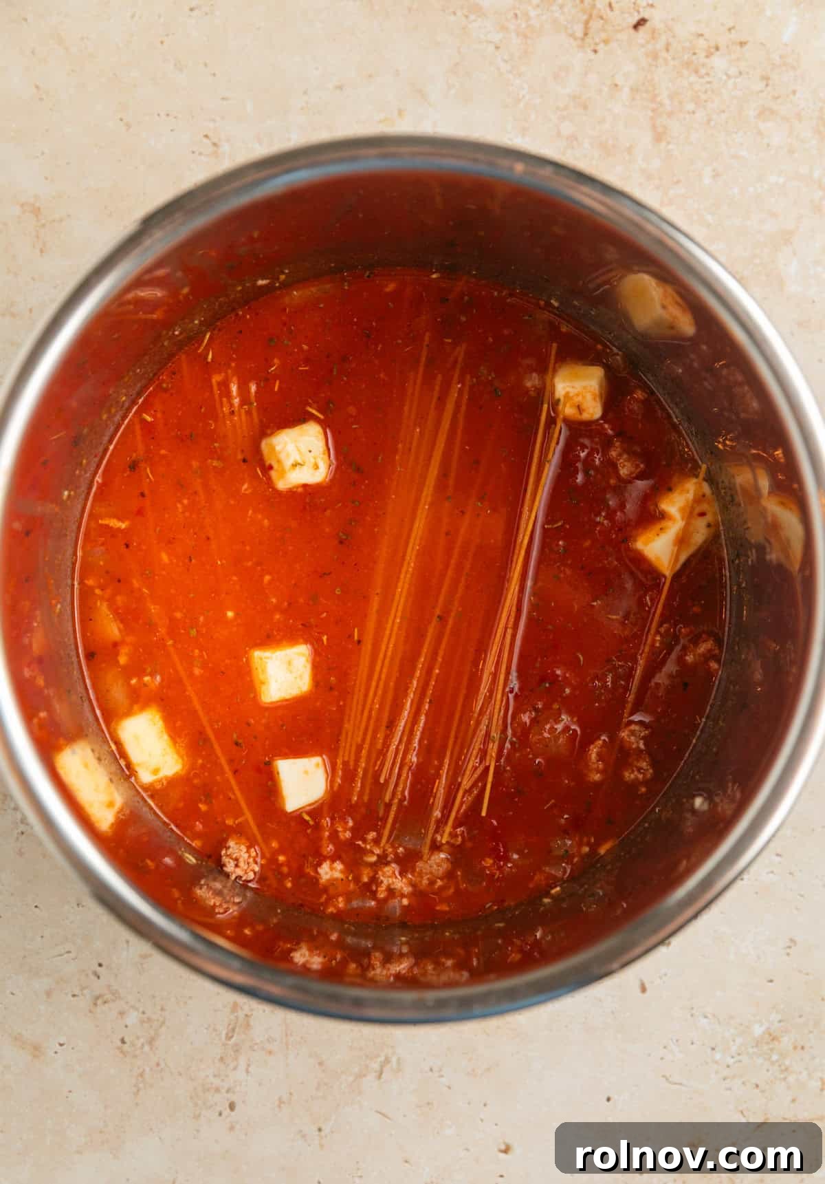 One-Pot Wonder Spaghetti 7 Instant Pot filled with browned ground turkey, broth, marinara sauce, seasonings, broken thin spaghetti, and cubed butter, layered and ready for pressure cooking.