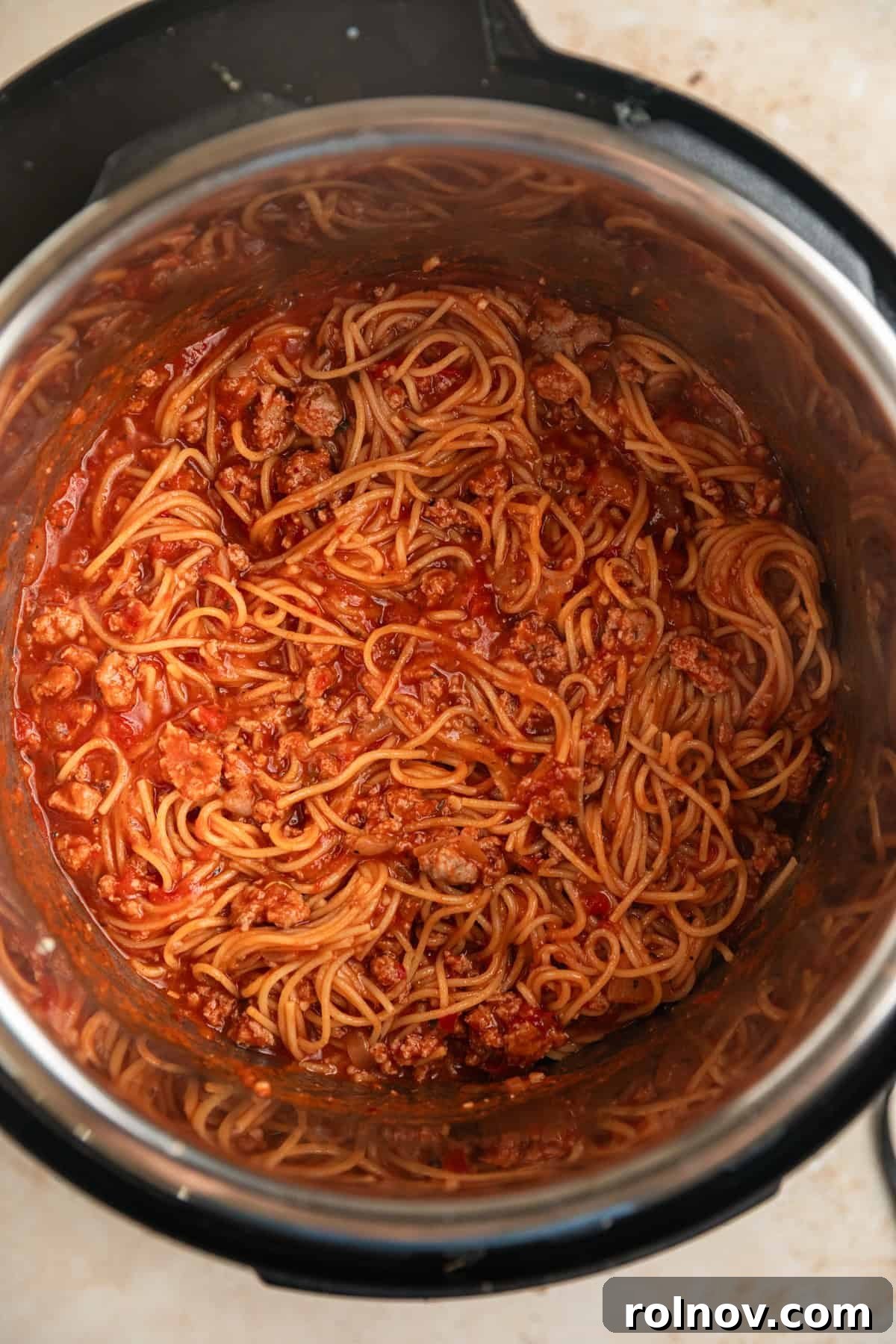 One-Pot Wonder Spaghetti 8 Cooked Instant Pot spaghetti with meat sauce, ready to be stirred, glistening with sauce inside the Instant Pot.