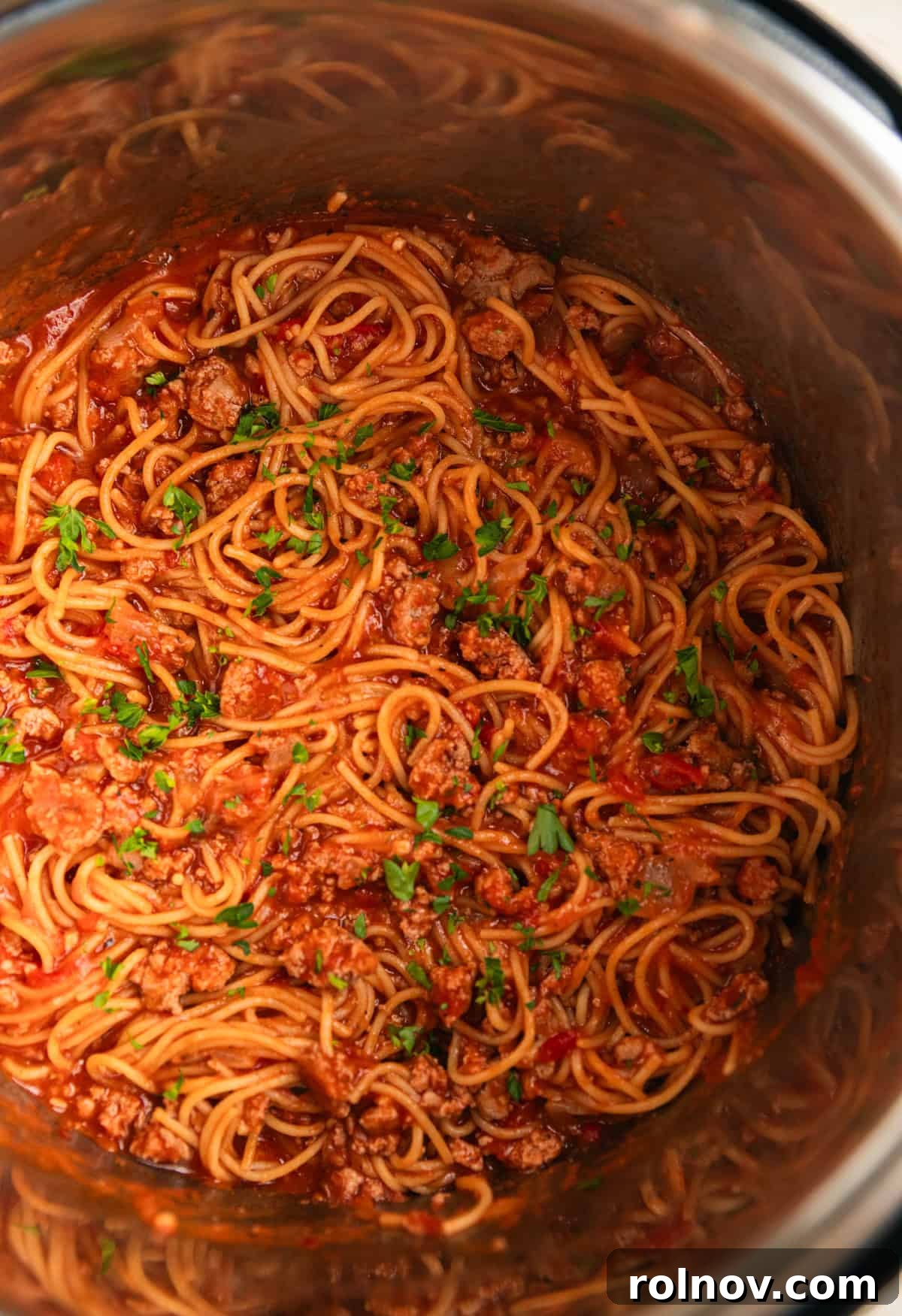 One-Pot Wonder Spaghetti 9 Close-up of Instant Pot spaghetti with meat sauce, topped with fresh chopped parsley, glistening and ready to serve.